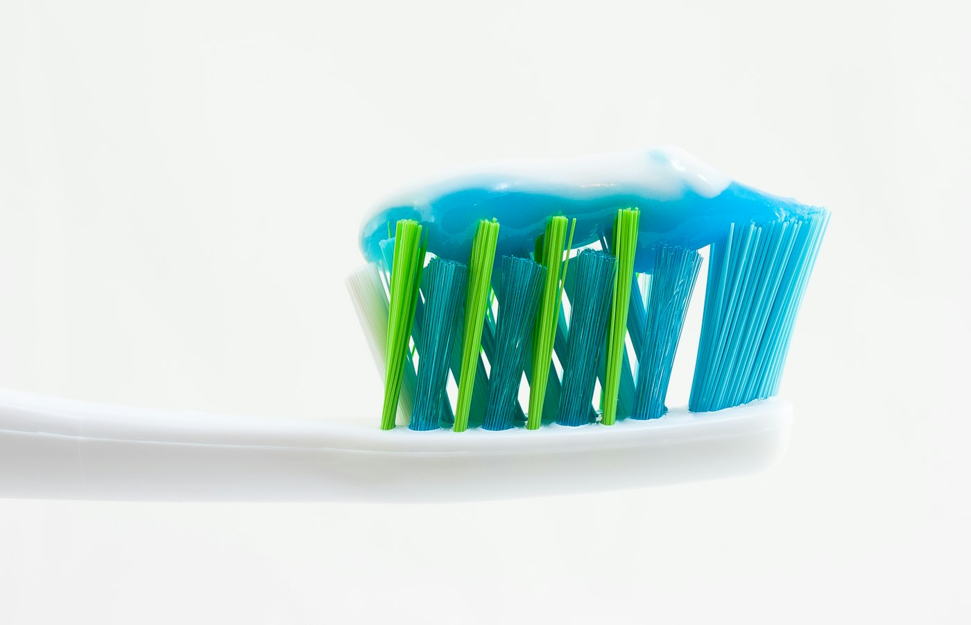 A toothbrush with toothpaste against a white background