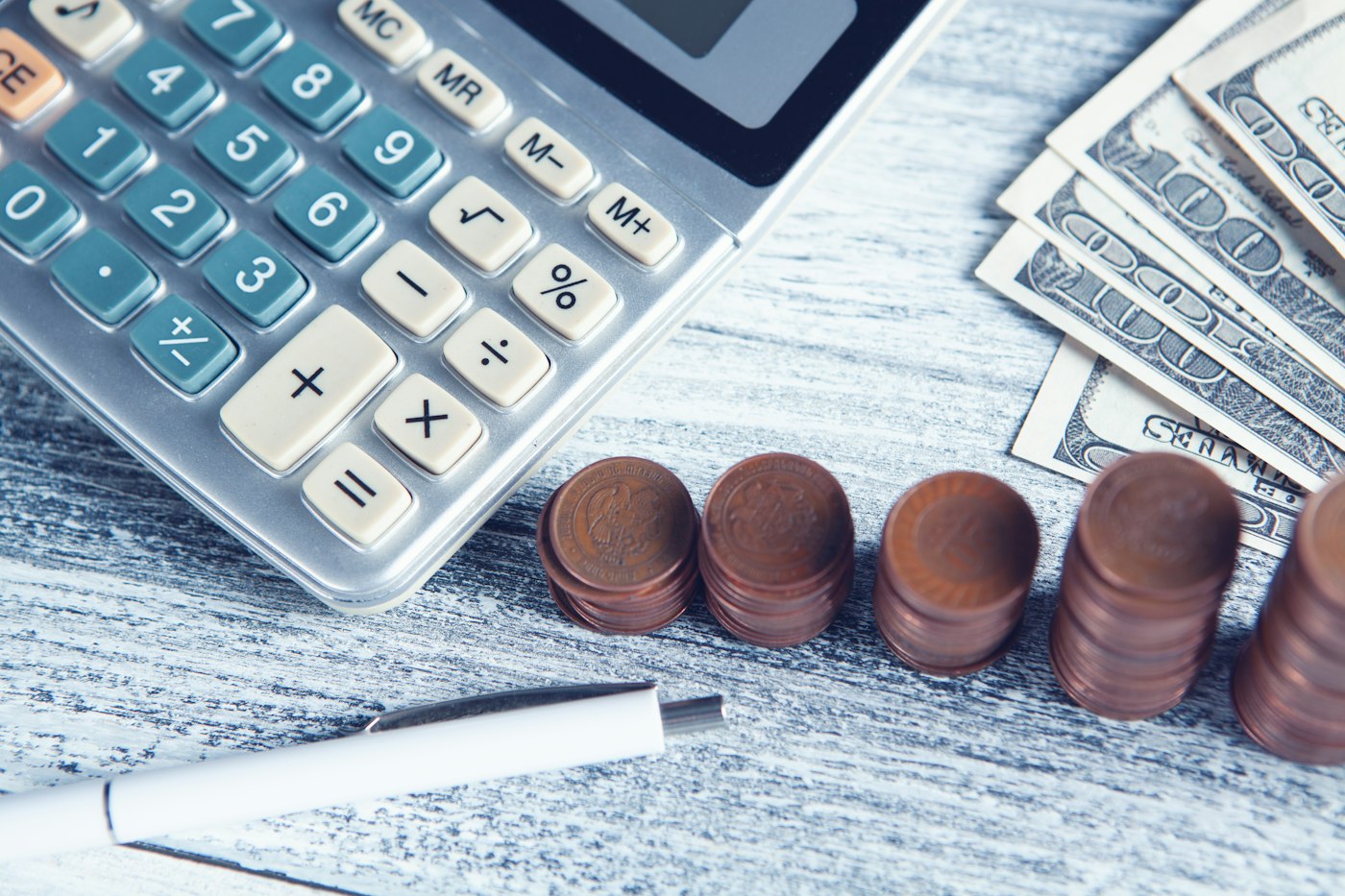 Calculator, pen and banknotes on a table