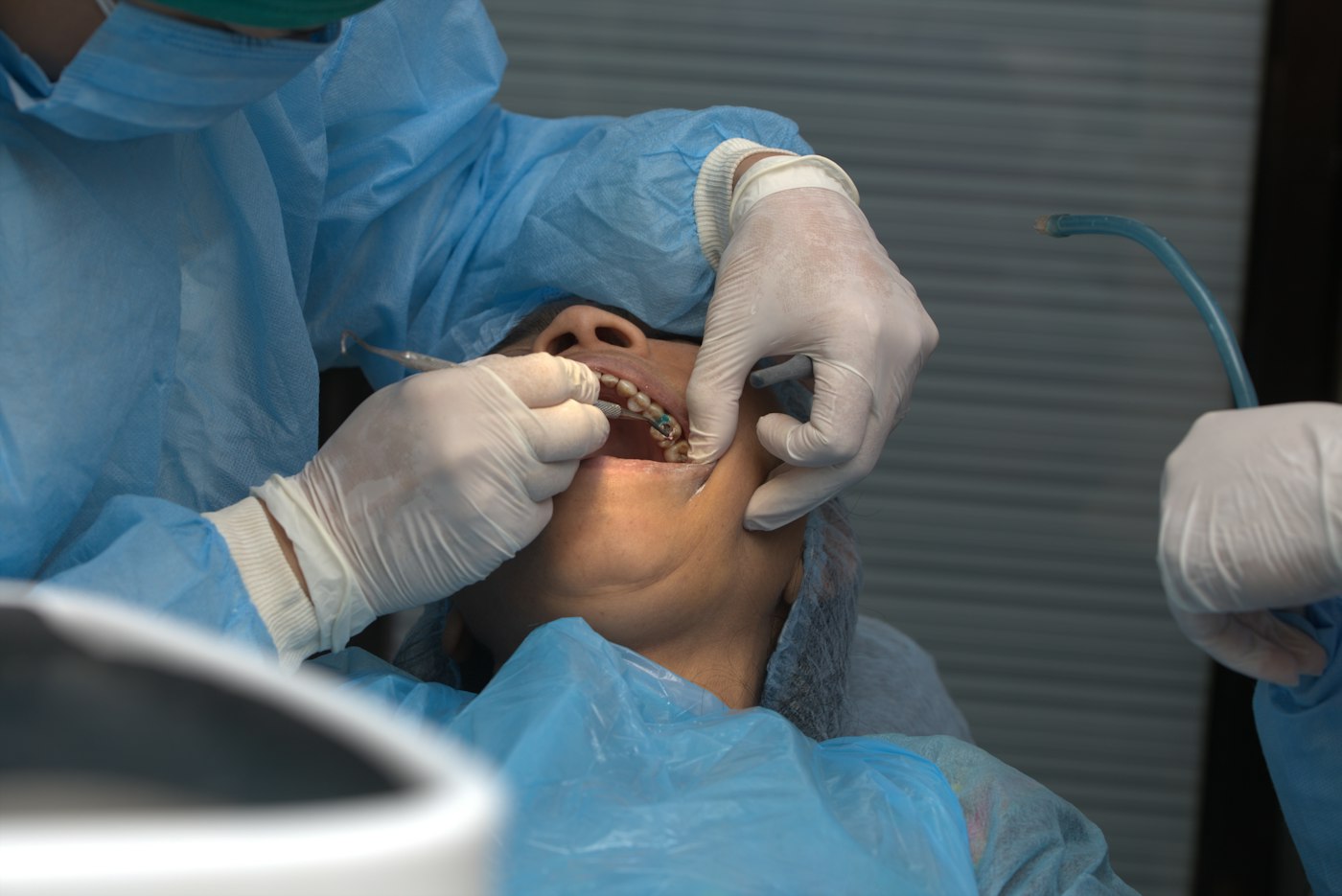 A dentist examining a patient in the dental chair at an Indian clinic