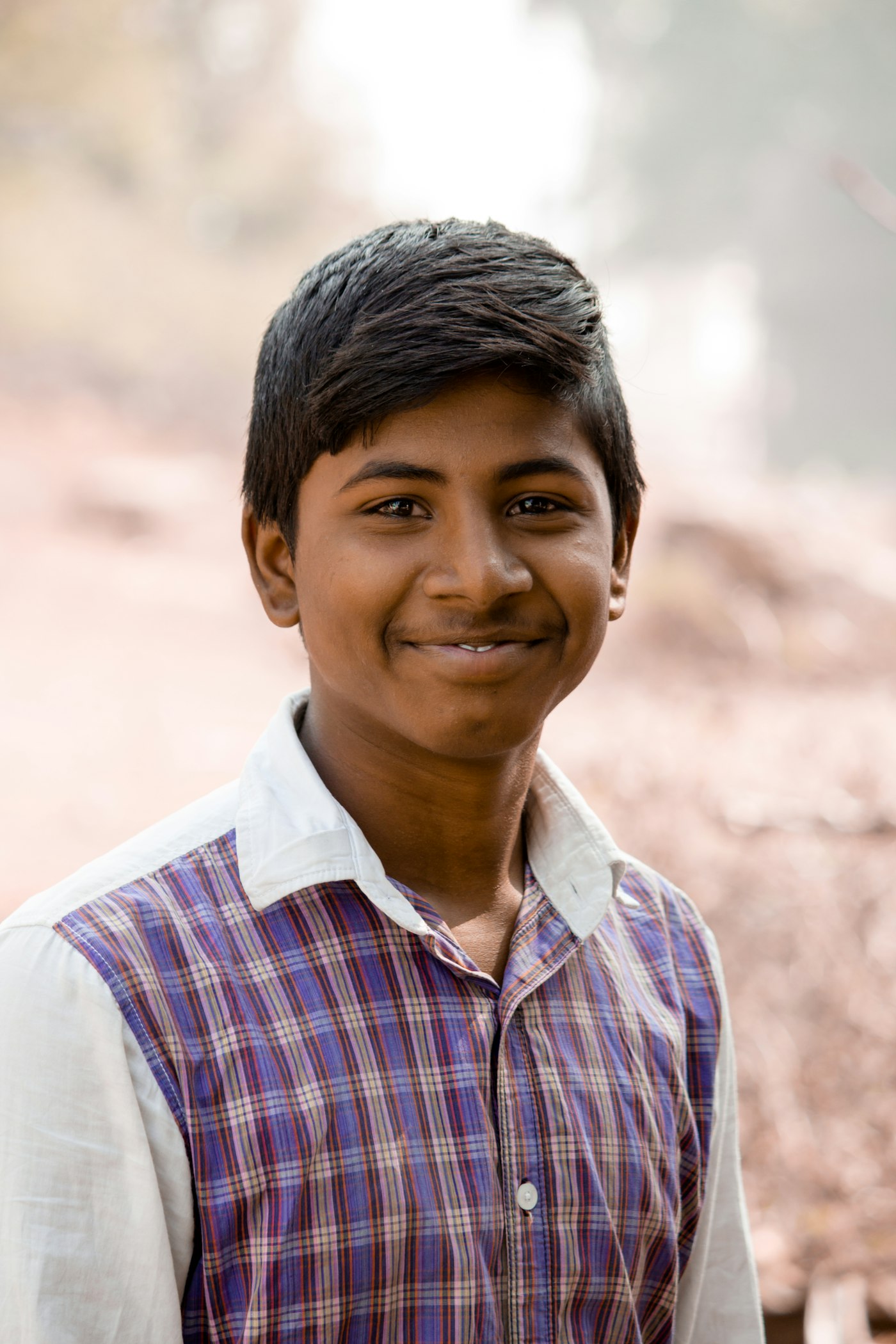A young Indian man laughing with a bright smile